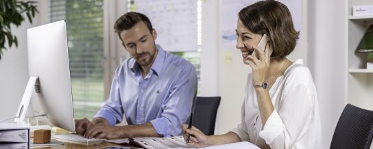 Male and female project manager collaborating in front of computer screen at office, Fast Forward Procurement