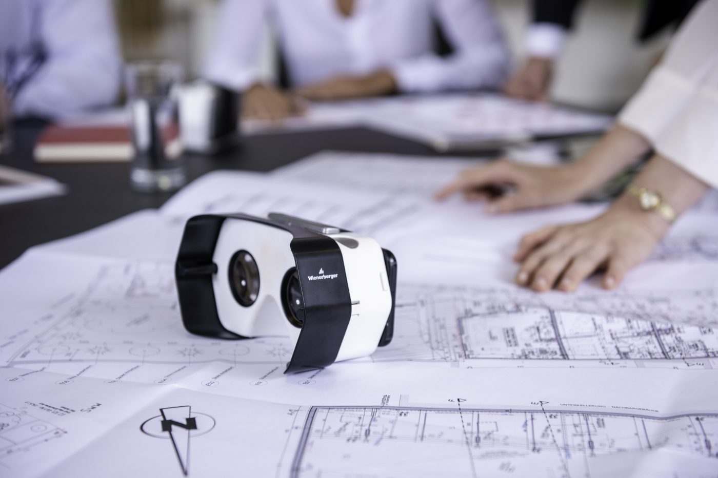 Virtual headset and blueprints at conference table