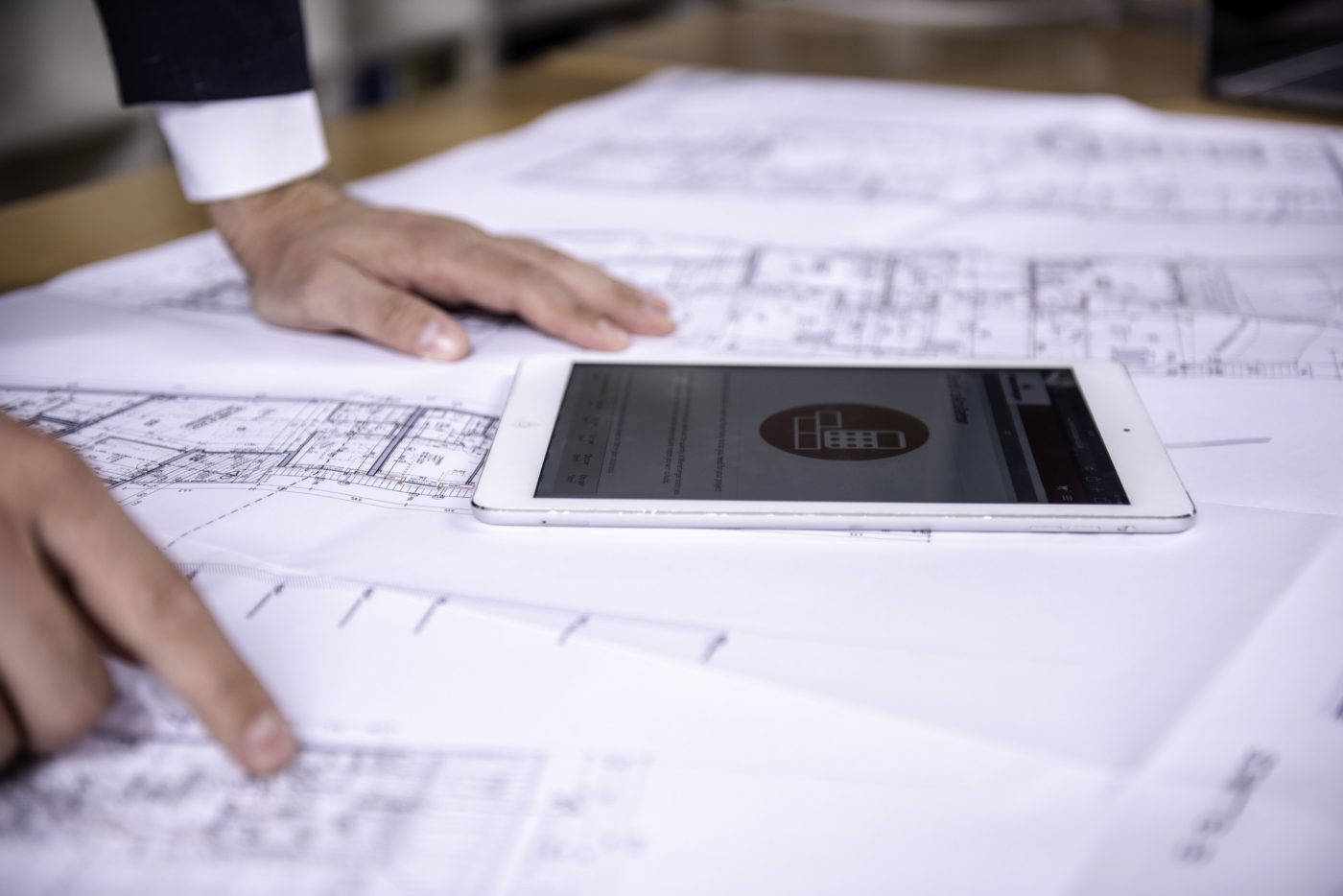 Tablet computer and hands at blueprint