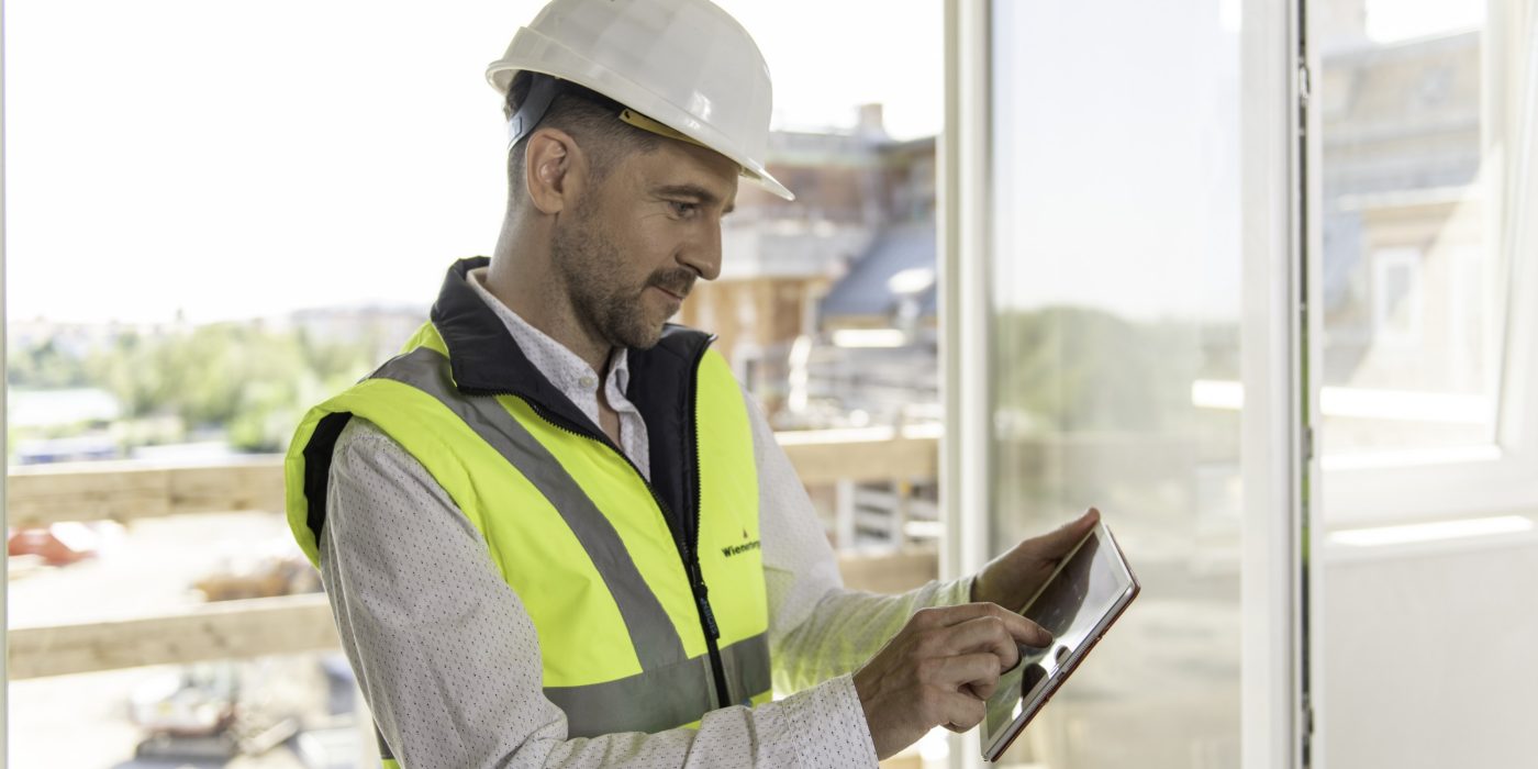 Architect or project manager using mobile device at construction site