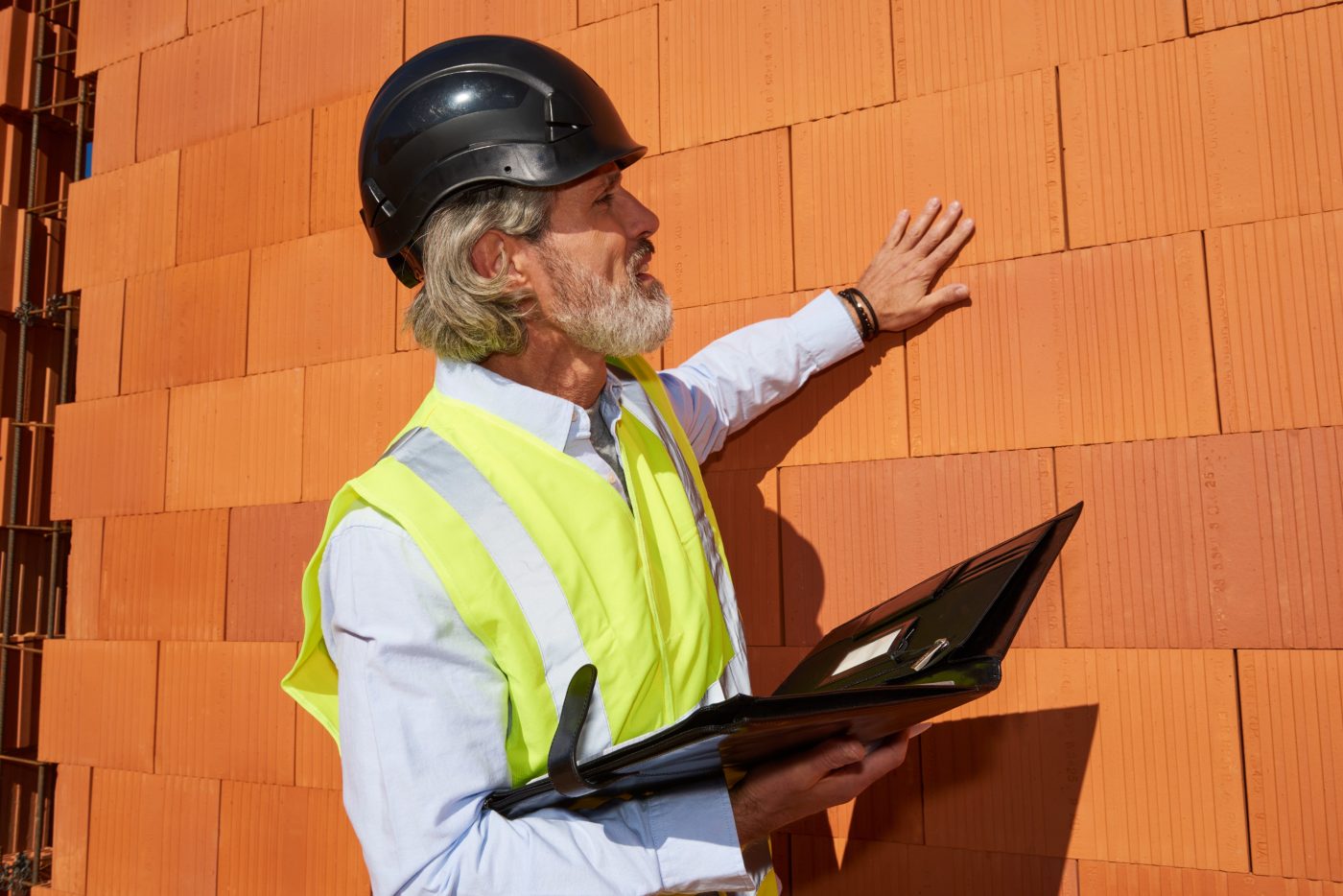 Architekt na budowie stojący przy ścianie z pustaków Porotherm Dryfix