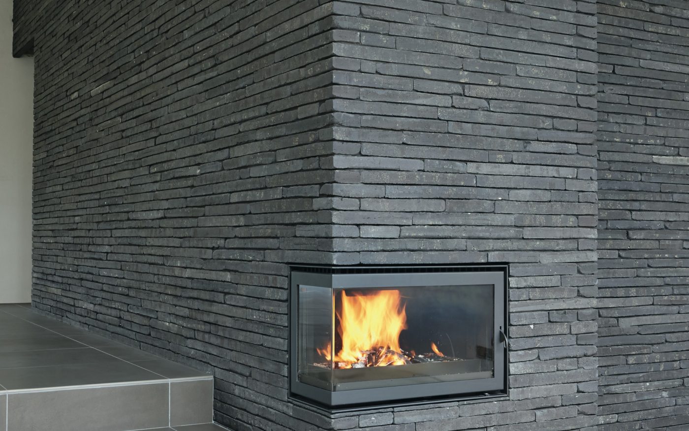 Kominek obłożony ciemną płytką klinkierową