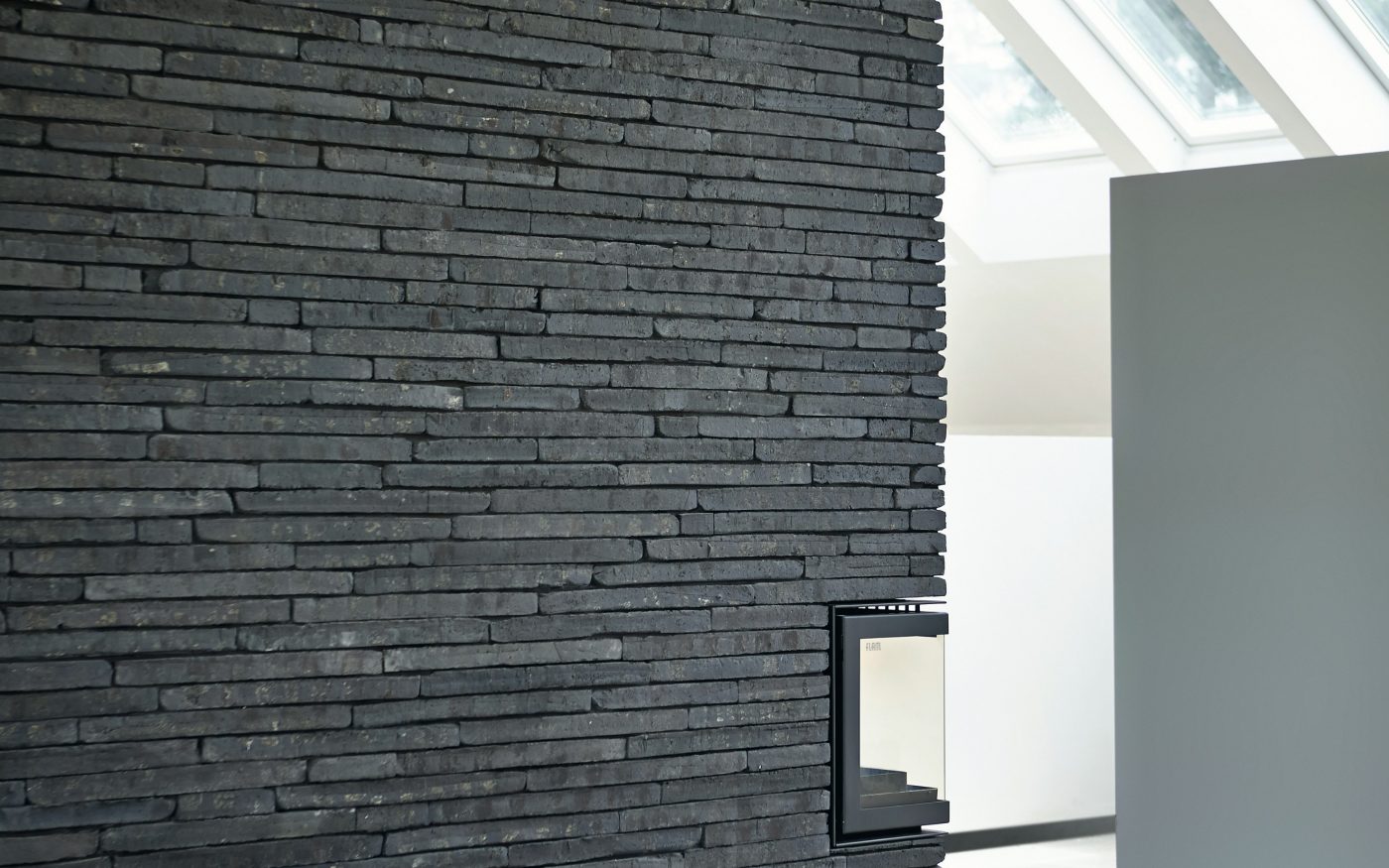 Kominek obłożony ciemną płytką klinkierową