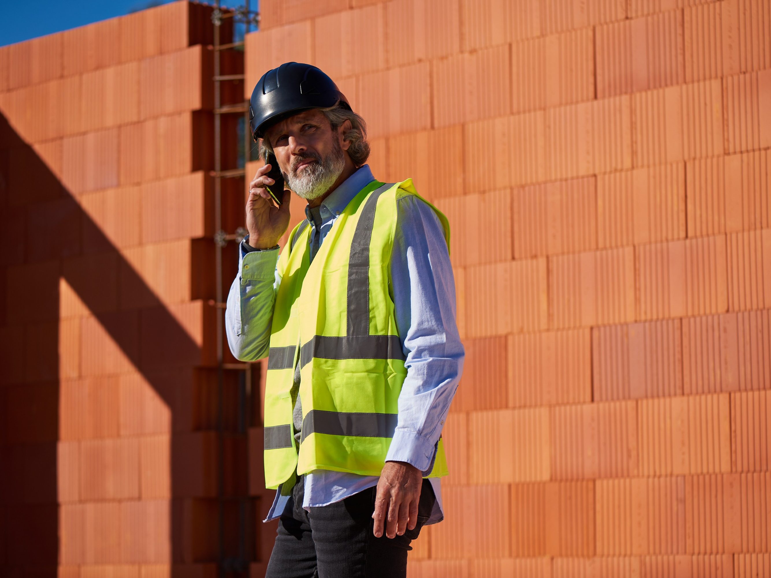 Architekt na budowie stojący przy ścianie z pustaków Porotherm Dryfix