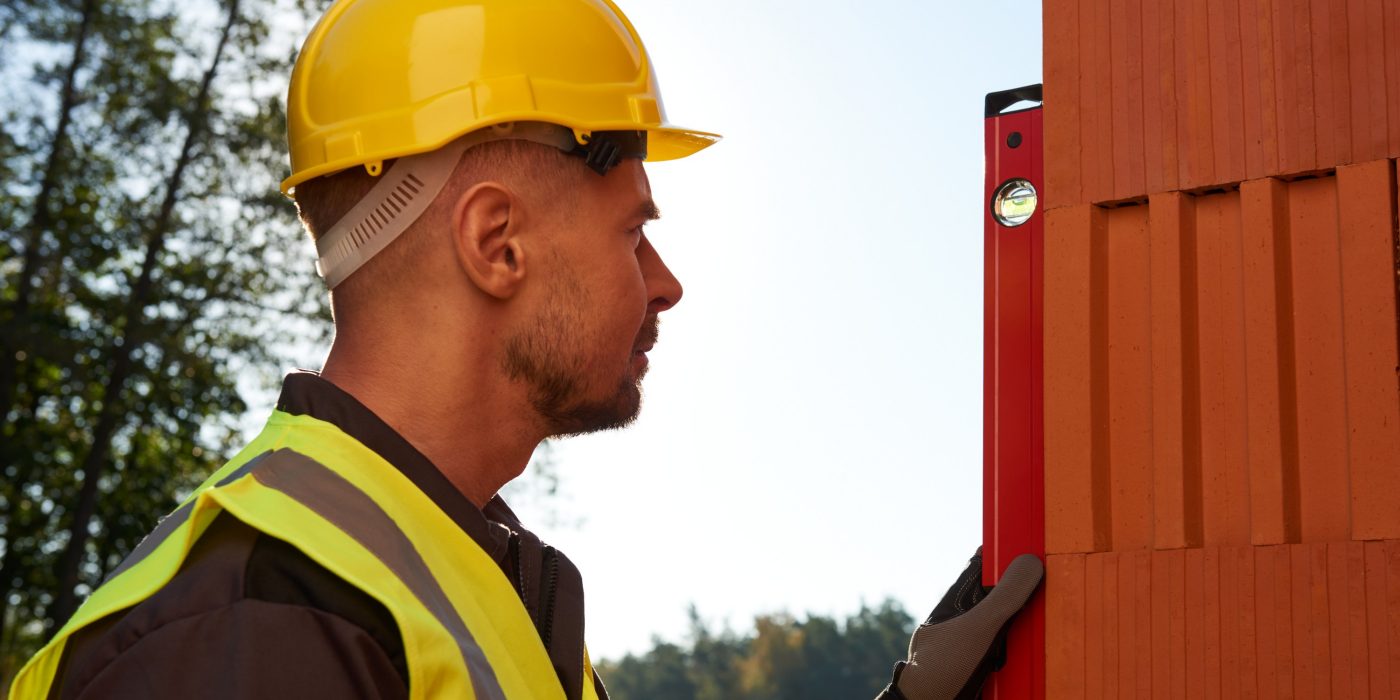 Murarz budujący z pustaków Porotherm Dryfix