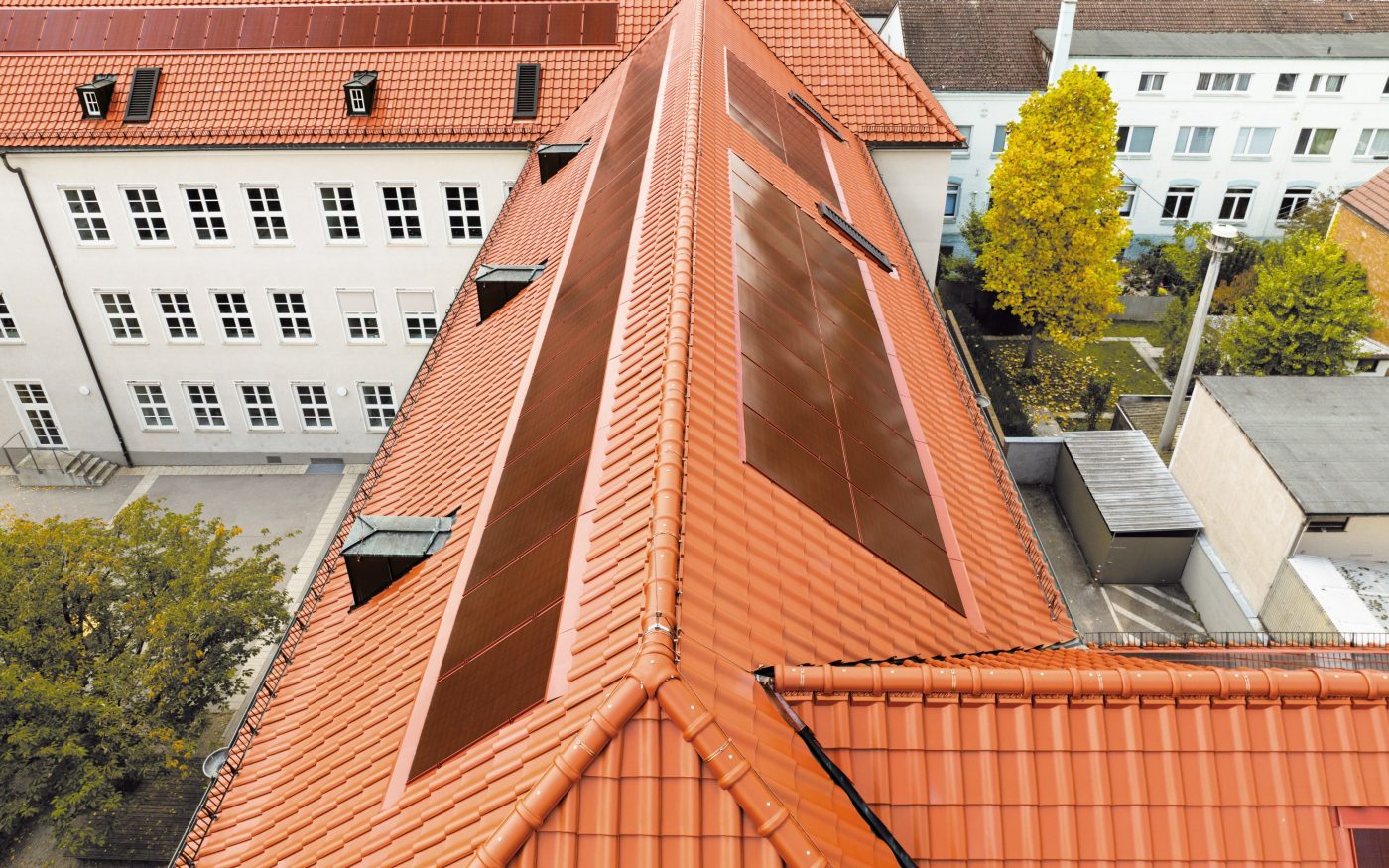 Dach z czerwonymi panelami fotowoltaicznymi Wevolt X-Frame