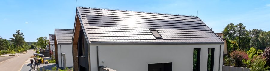 Dom z panelami fotowoltaiczynymi Wevolt X-Tile w kolorze czarnym i płaską dachówką ceramiczną Orea 9 w kolorze szarej angoby