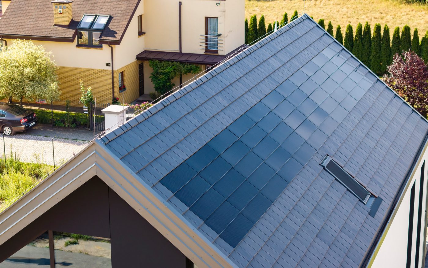 Dom z panelami fotowoltaiczynymi Wevolt X-Tile w kolorze czarnym i płaską dachówką ceramiczną Orea 9 w kolorze szarej angoby