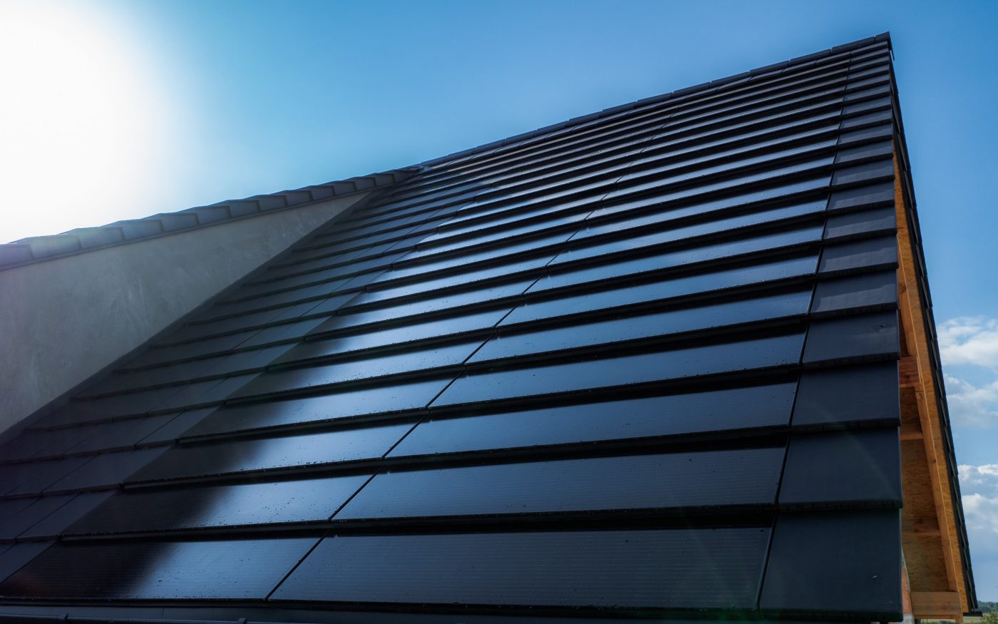 Dom jednorodzinny w Mechnicach z panelami fotowoltaicznymi Wevolt X-Tile w kolorze czarnym i płaską dachówką ceramiczną Orea 9 antarcytowej matowej angoby