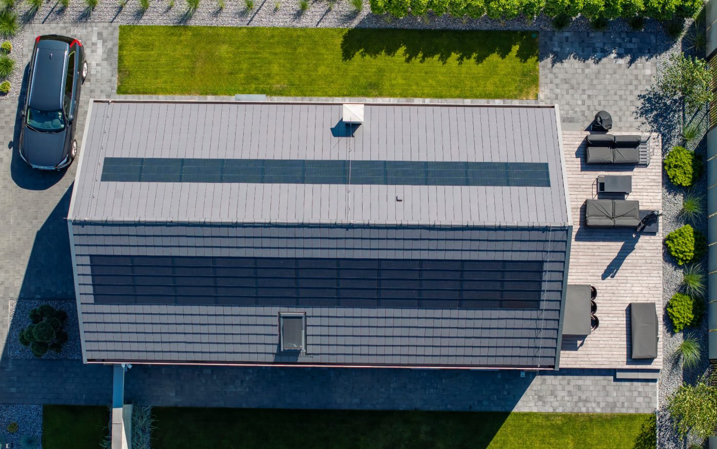 Dom z panelami fotowoltaiczynymi Wevolt X-Tile w kolorze czarnym i płaską dachówką ceramiczną Orea 9 w kolorze szarej angoby